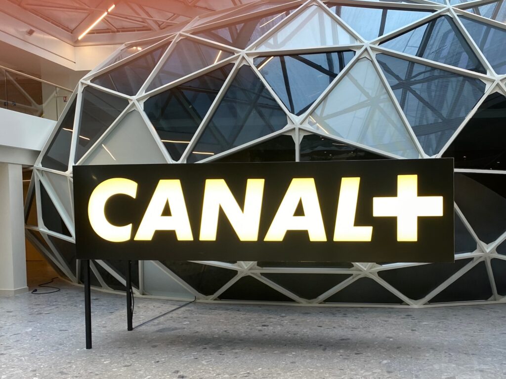 Illuminated Canal+ sign in front of a glass geodesic dome